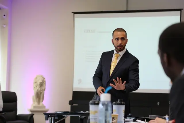 Birol Isik hält einen Vortrag vor Teilnehmenden